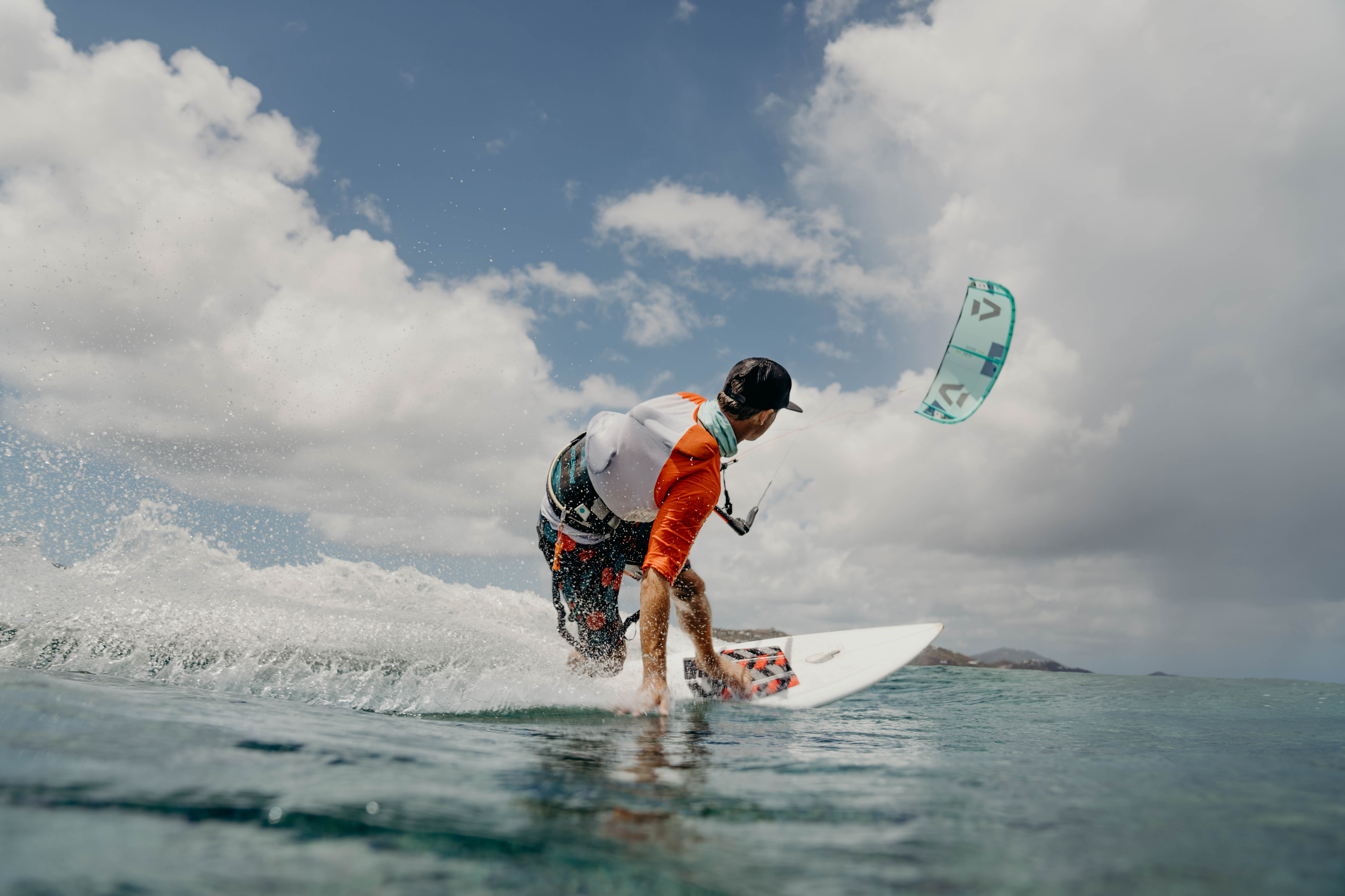 Kitesurfer carving across the water with a teal kite aloft in the British Virgin Islands