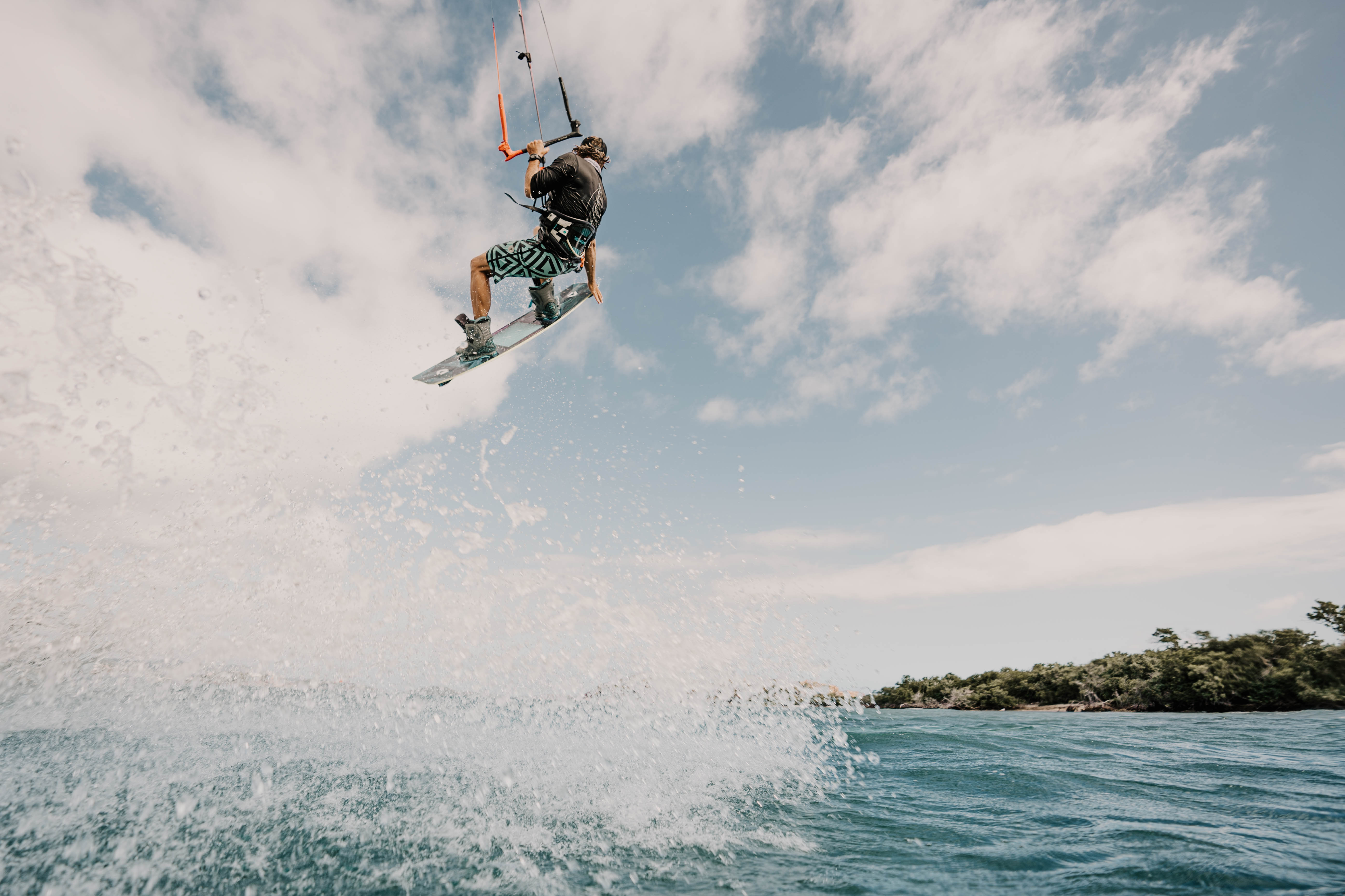 Kitesurfer boosting a big air jump over turquoise Caribbean water during the first Virgin Crossings edition